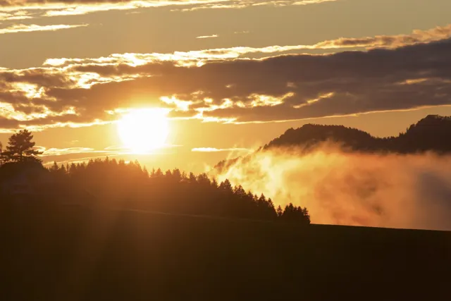 Sonnenaufgang über Hügeln mit Nebel