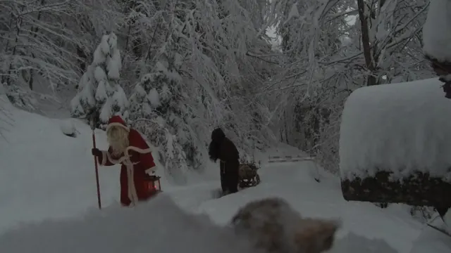 Samichlaus mit Laterne und Schmutzli mit Schlitten im Tiefschnee